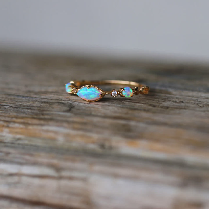 Opalring aus Gold mit Diamanten, eleganter Schmuck, handgefertigt, auf Holzoberfläche.