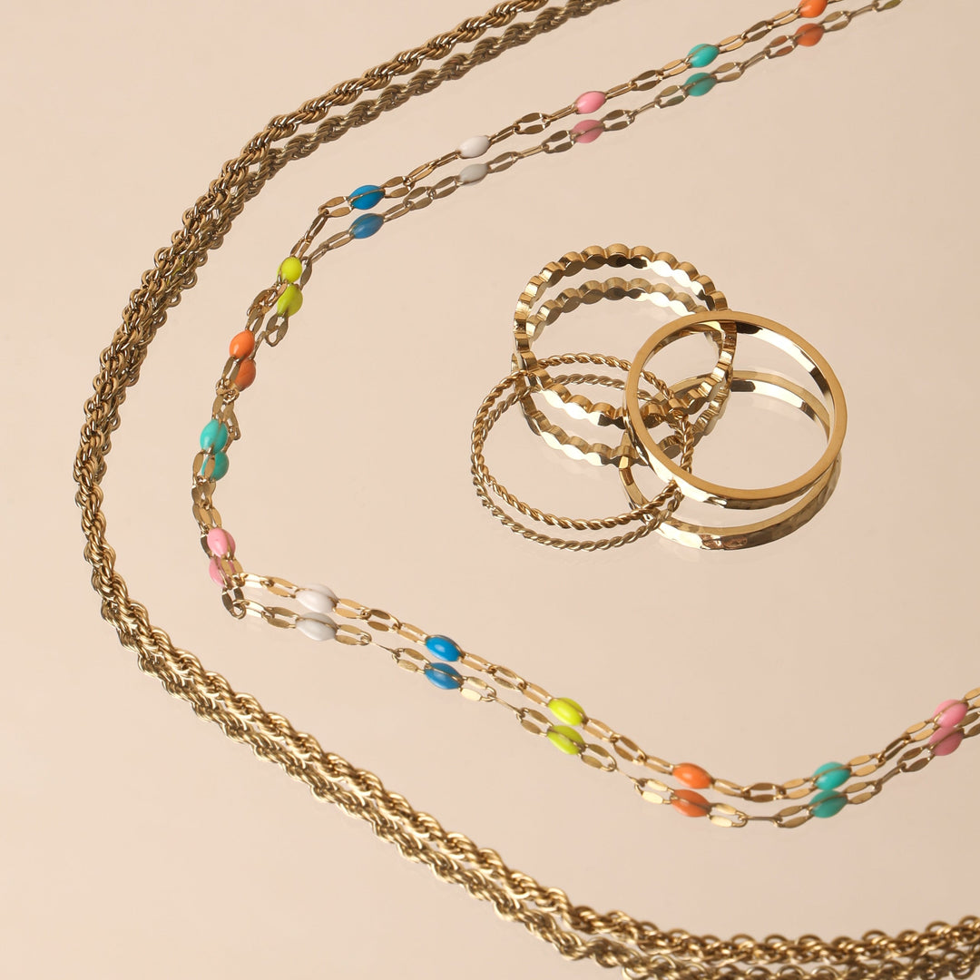 Dame trägt goldenen Regenbogen Choker mit Emaille. Wasserfeste, hypoallergene Halskette, ideal für jeden Anlass.