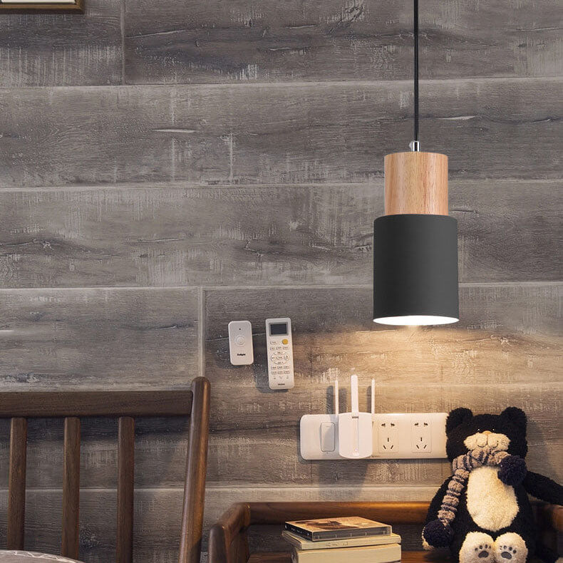 Schwarze Hängeleuchte aus Holz über Nachttisch mit Büchern und Teddybär, modernes Design.