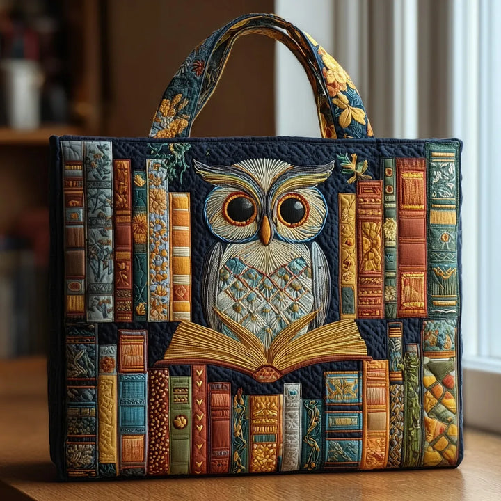 Nahaufnahme einer handgefertigten blauen Tragetasche mit detailliertem Eulenmotiv und bunten Büchern darauf, auf einem Holzti