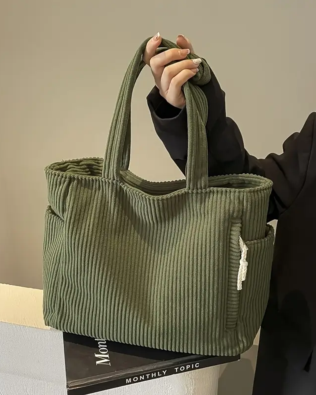 Hand hält grüne gerippte Tragetasche mit Kordel-Detail