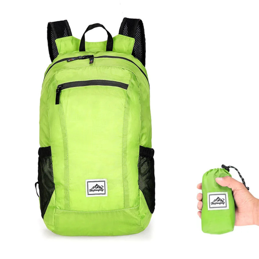 Leichter, grüner Rucksack entfaltet neben seiner kompakten, gefalteten Form in einer Hand.