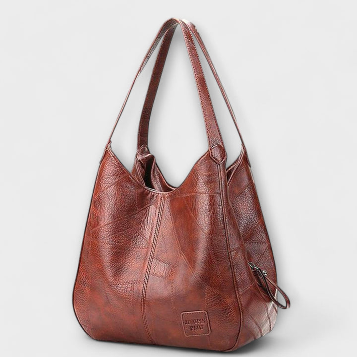 Damen Vintage Handtasche in Braun stehend vor neutralem Hintergrund