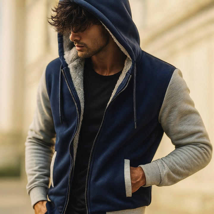 Die zweifarbige Herrenjacke mit Kapuze kombiniert Funktionalität und trendiges Design.