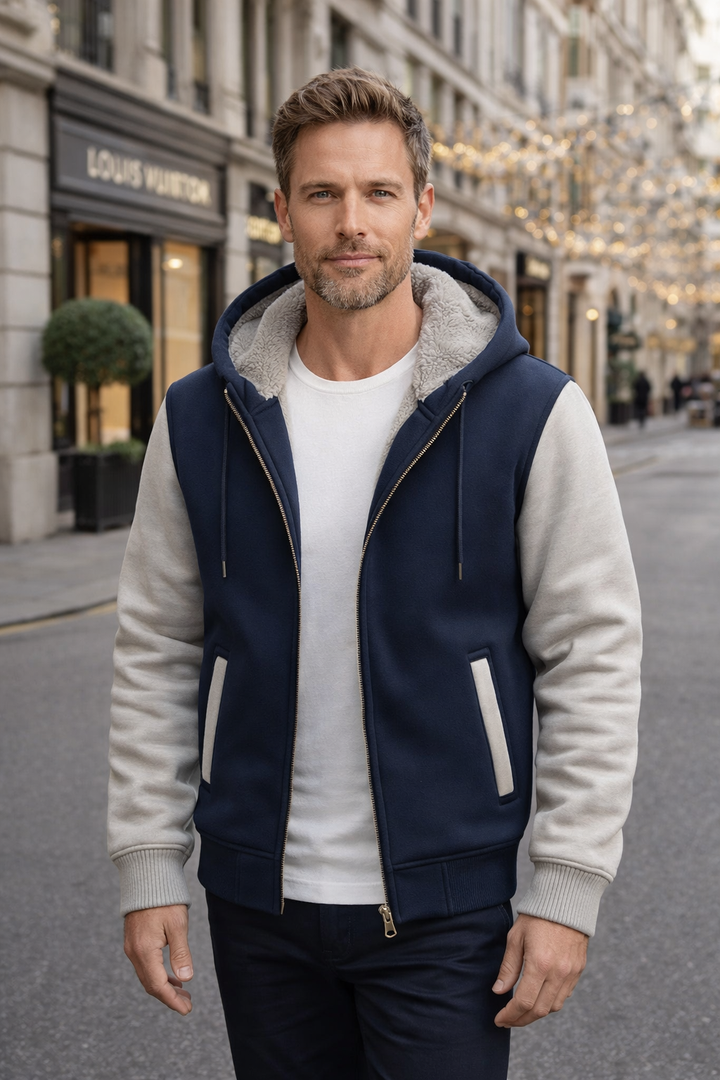 Seitenprofil des Mannes, der die Kapuzenjacke mit Kontrastfarben und weichem Futter präsentiert.