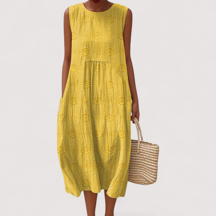 Frau trägt lockeres, ärmelloses Damen Sommerkleid mit floralem Print. Bequem und leicht für den Sommer.
