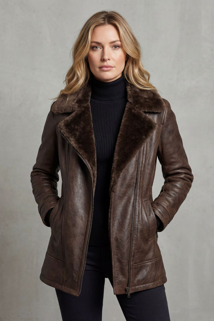 Blonde Frau trägt braune Jacke mit hochgeschlossenem Rollkragenpullover, Blick nach vorne.