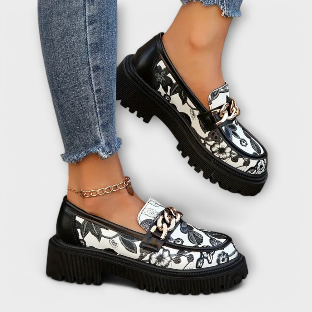 Schwarze Slipper mit floralem Muster und dicker Sohle im Detail