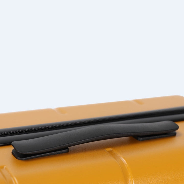 Eleganter grauer Hartschalen-Trolley, Nahaufnahme der leisen Doppelrollen.