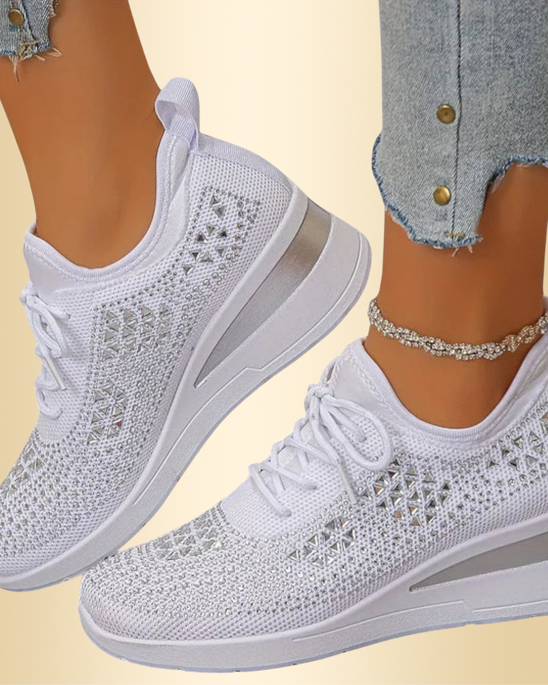Nahaufnahme von weißen Damen Glitzer-Sneakern mit Schnürung, getragen zu Jeans und Fußkettchen.
