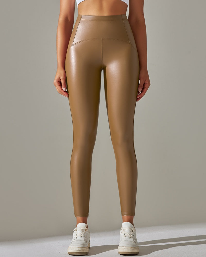 Vorderansicht einer Frau in braunen High-Waist-Leggings mit glänzender Optik