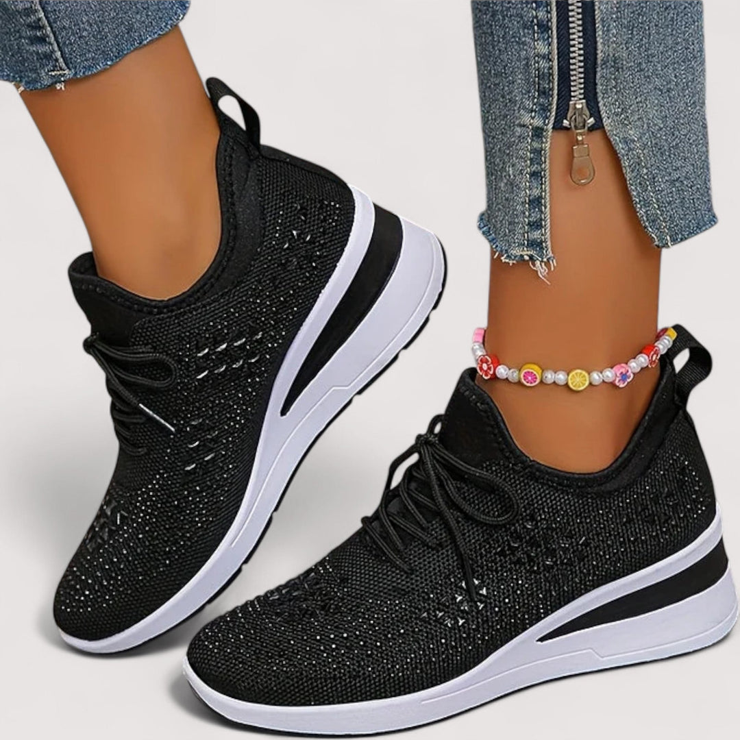 Detail der Schnürung und der glitzernden Oberfläche der weißen Damenschuhe.