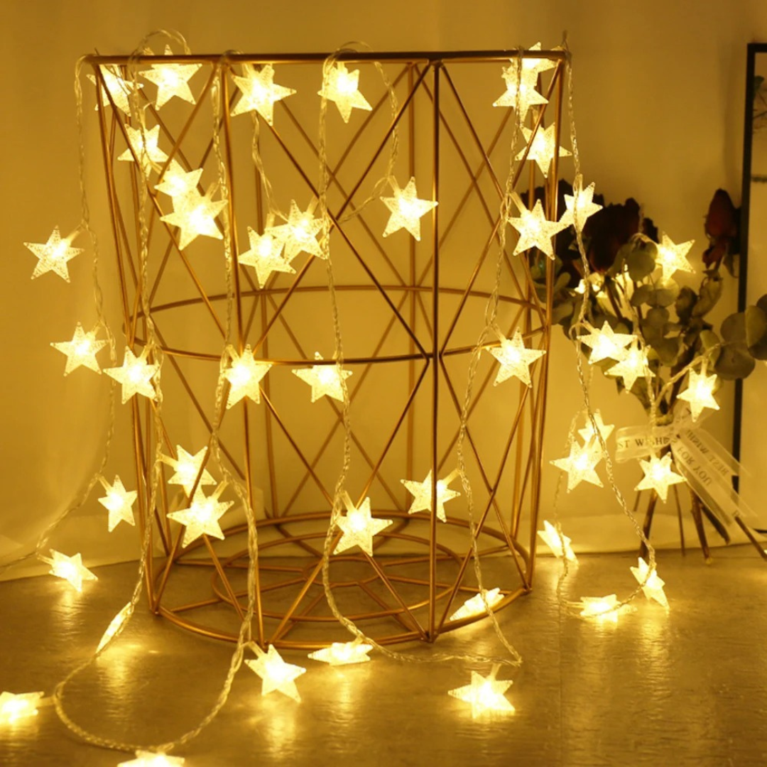 Dekorative Stern Lichterkette drapiert in einem goldenen Drahtkorb