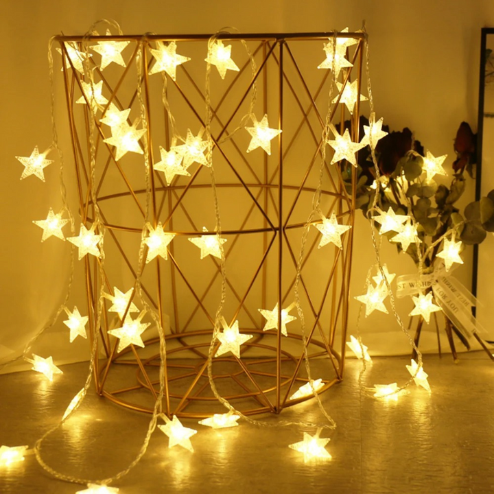 Dekorative Stern Lichterkette drapiert in einem goldenen Drahtkorb