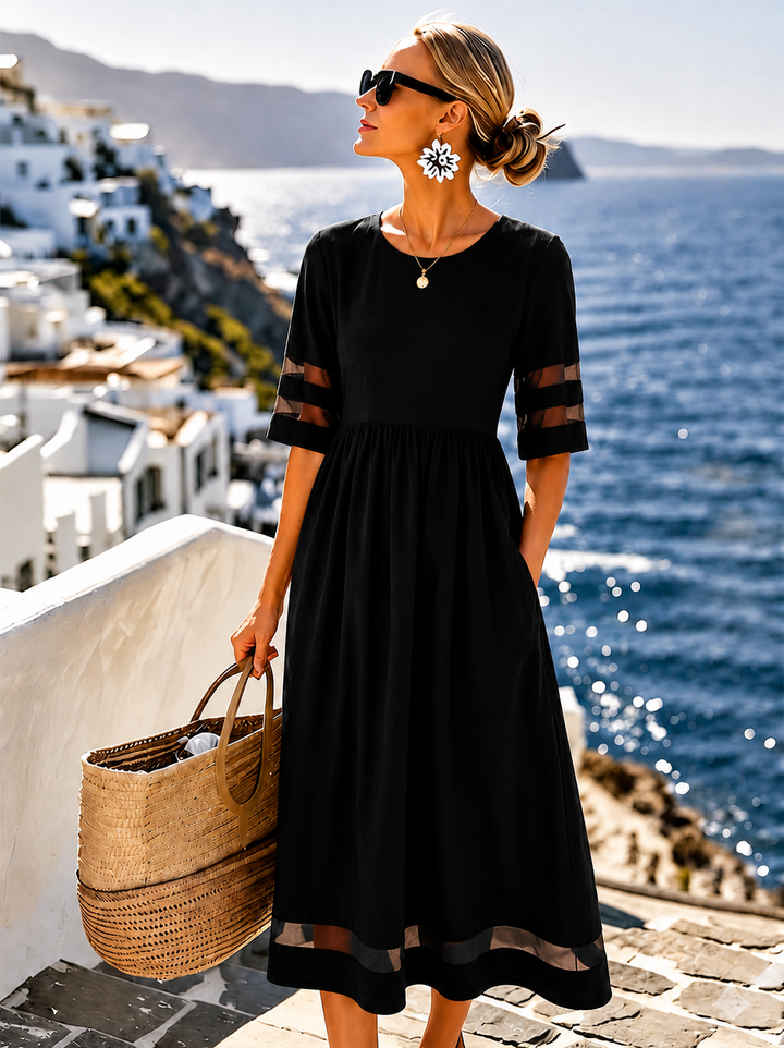 Damen Midi-Kleid in Schwarz mit figurbetonter Silhouette vor mediterraner Küstenkulisse