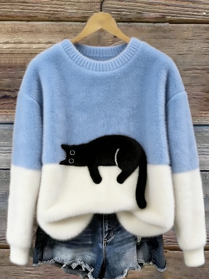 Hellblauer Oversized Pullover mit Katzenmotiv auf einem Holzbügel