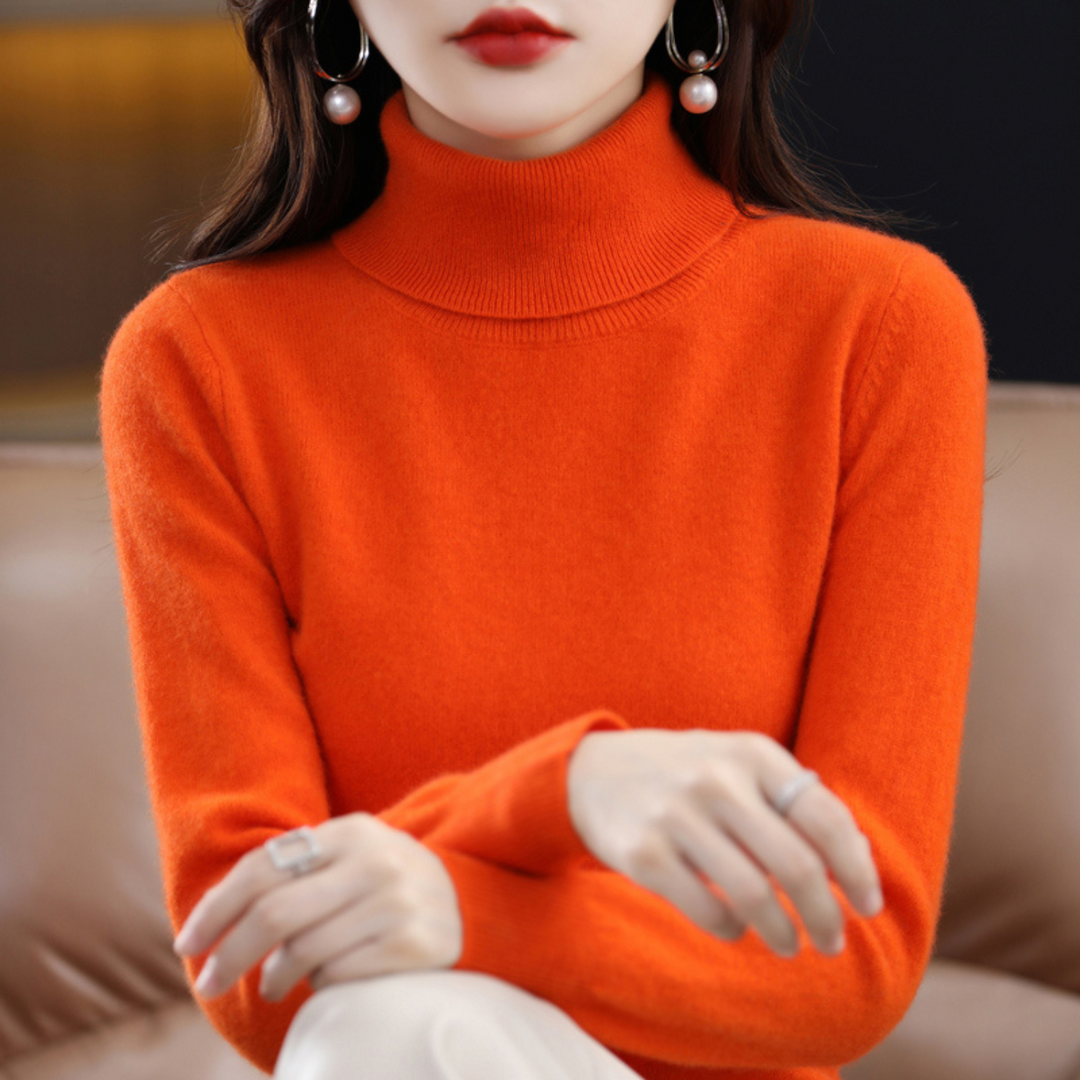 Frau in orangefarbenem Rollkragenpullover aus Kaschmir, elegante Ohrringe, stilvolle Mode.
