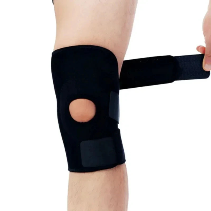 Nahaufnahme einer schwarzen Knie-Stützbandage mit offenem Kniebereich an einem Bein.