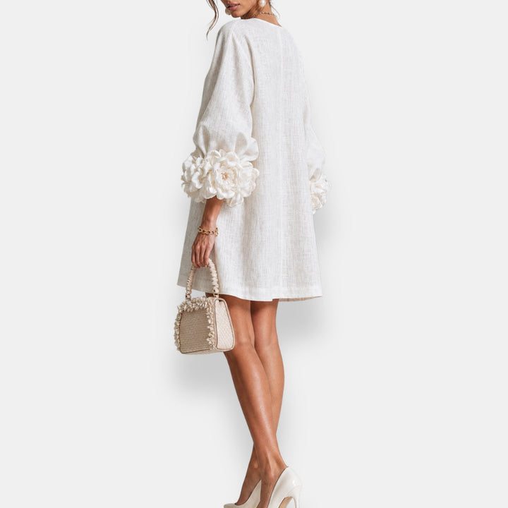 Detailaufnahme des Blütenreliefs am weißen Damen Sommerkleid