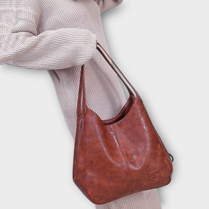 Damen Vintage Schultertasche in Braun am Arm einer Person getragen