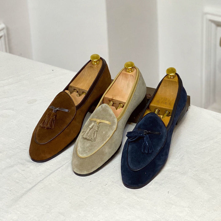 Drei Paar elegante Herren Loafer mit Quasten in Blau, Caffee und Khaki nebeneinander