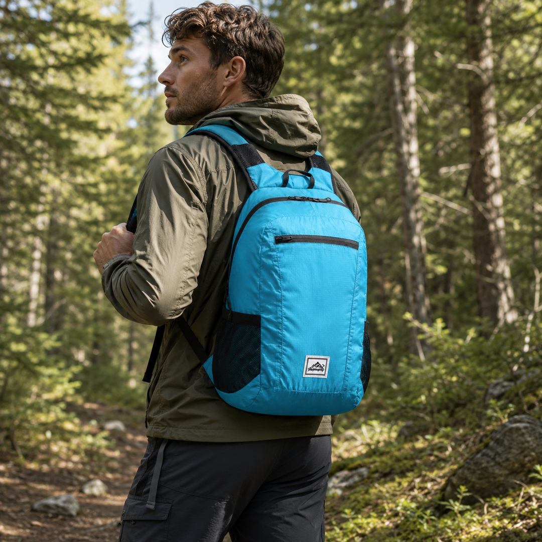 Mann trägt einen blauen, faltbaren 20L Tagesrucksack beim Wandern im Wald.