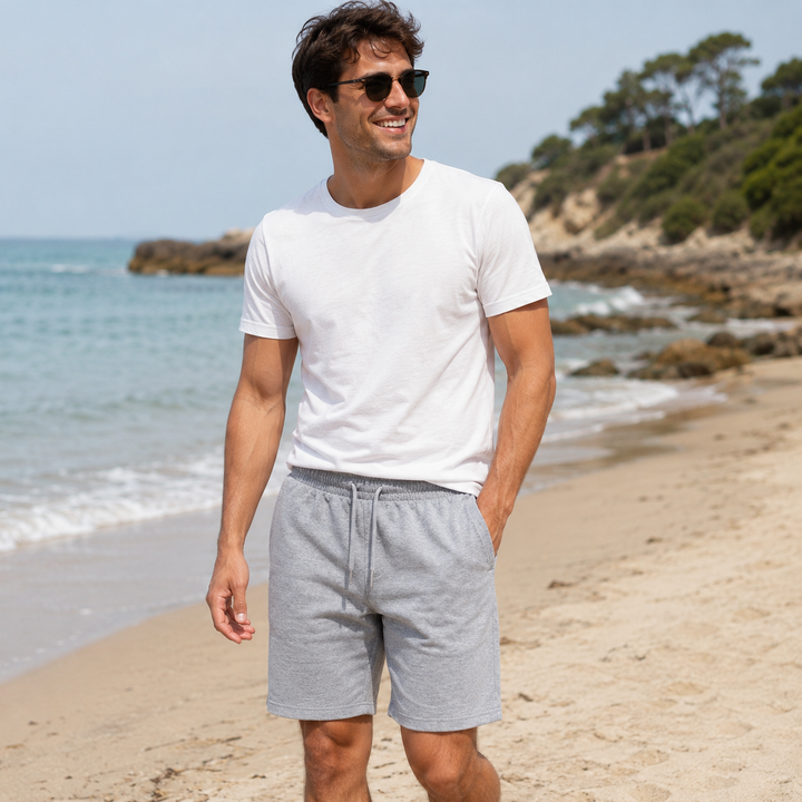 Mann am Strand trägt helle graue Freizeit-Shorts mit Kordelzug