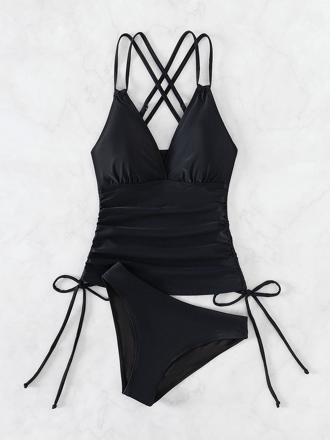 Damen Tankini in Schwarz flach auf weißem Marmor gelegt