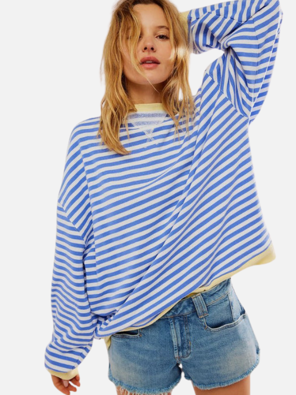 Frau in einem himmelblau gestreiften Oversized Sweatshirt im Sonnenschein