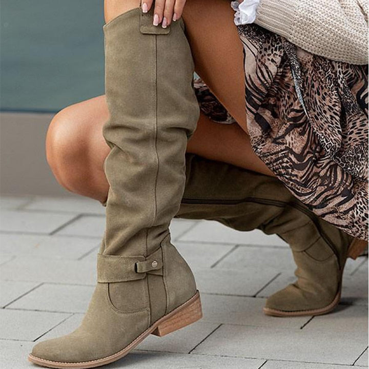 Graue Damenstiefel zeigen die seitliche Schnalle und den flachen Absatz