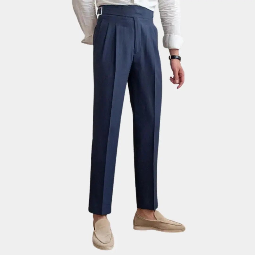 Ein Mann trägt eine elegante blaue Herren Gurkha-Hose mit weißem Hemd und Loafern von vorne.