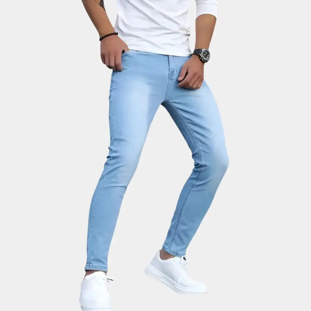 Herren trägt helle blaue Slim Fit Stretch Jeans mit weissem Oberteil