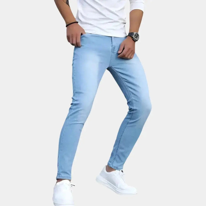 Herren trägt helle blaue Slim Fit Stretch Jeans mit weissem Oberteil