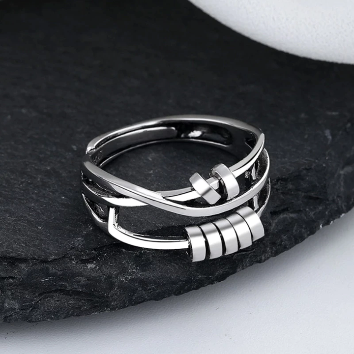 Silberner Edelstahlring mit modernem Design auf schwarzem Hintergrund.