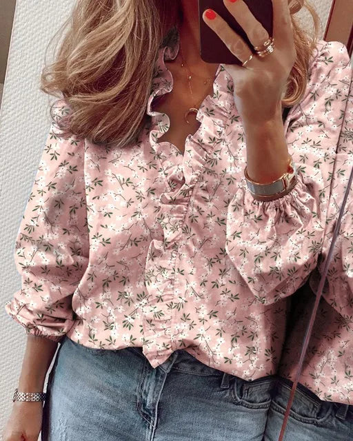 Rosa gemusterte Damenbluse mit Rüschen und langen Ärmeln, stilvoll getragen.