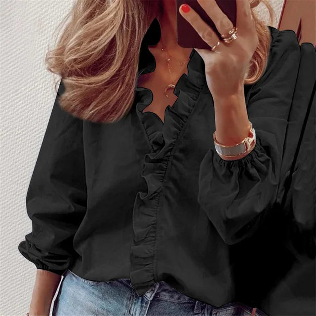 Schwarze elegante Damen Rüschenbluse für Büro und Abend, kombiniert mit Jeans.