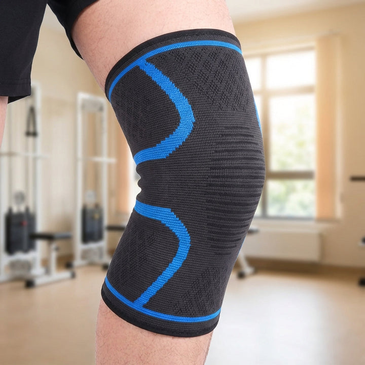 Unisex Kniekompressionsbandage in Schwarz mit blauem Akzent am Knie im Fitnessstudio