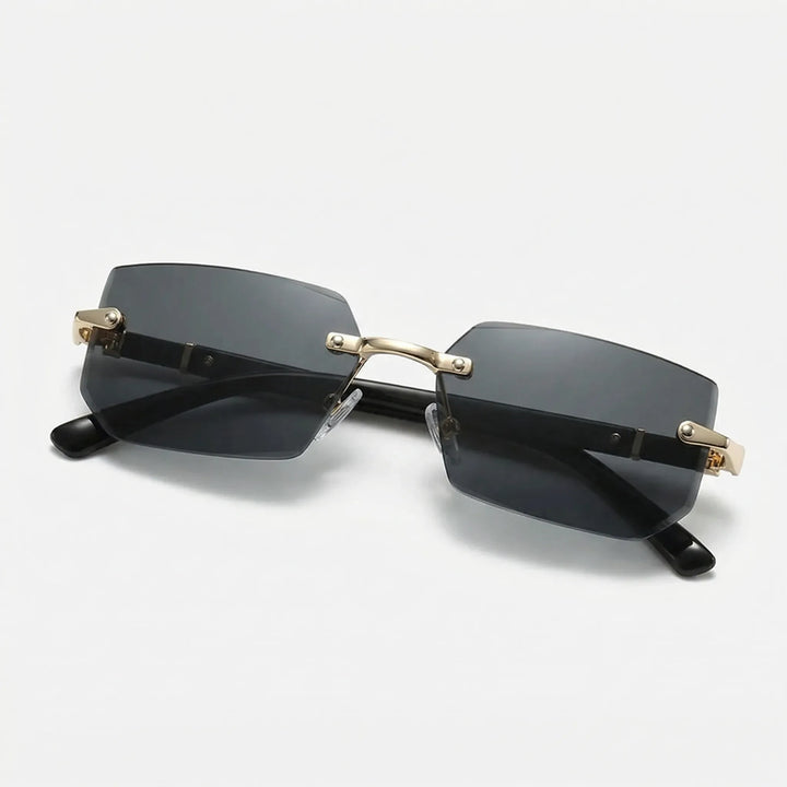Dunkle rahmenlose Rechteck-Sonnenbrille mit goldfarbenen Details auf hellem Hintergrund