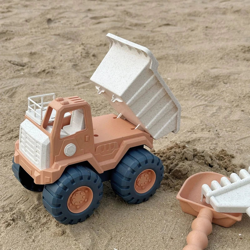 Kleinkinder spielen mit dem Sandspielzeug-Set am Strand, Meerestiere & Fahrzeuge.