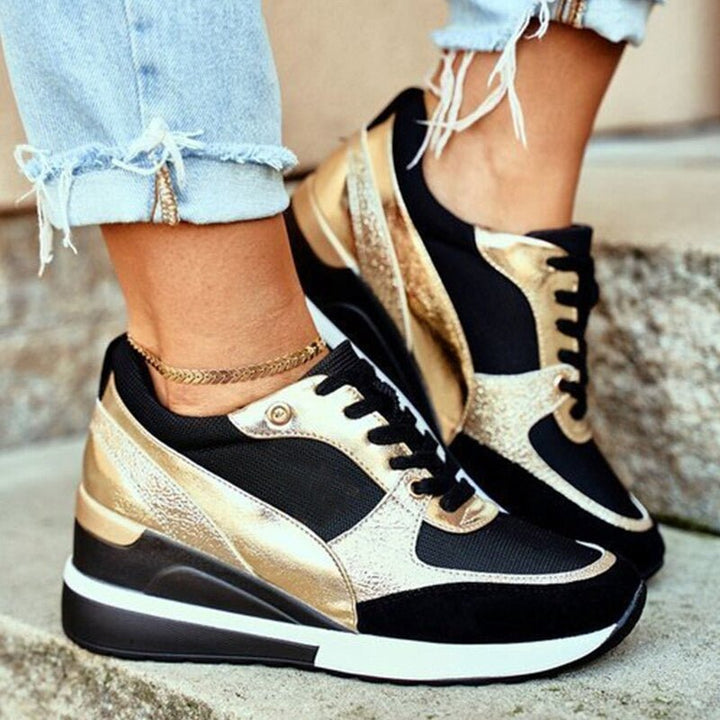 Orthopädische Damen Schnürschuhe in Schwarz und Gold an den Füßen getragen