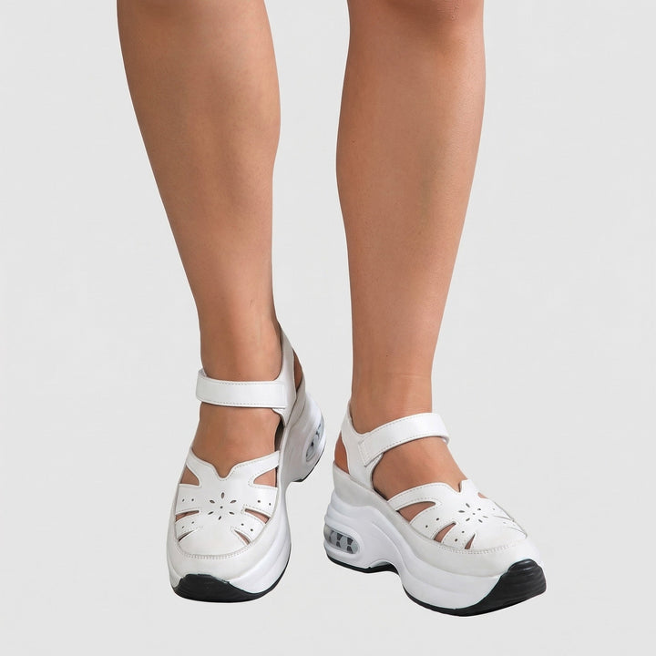 Weisse orthopädische Komfortsandalen für Damen an den Füßen getragen, Vorderansicht