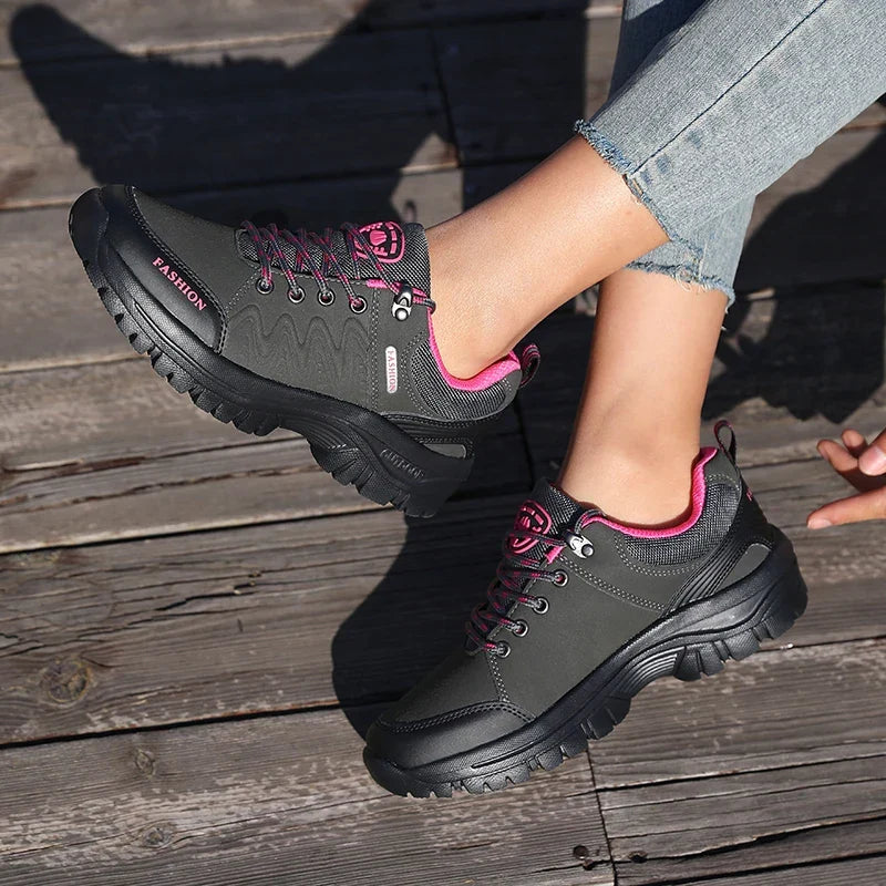 Damen Trekking Schuhe in Grau pastell am Fuß getragen auf Holzuntergrund