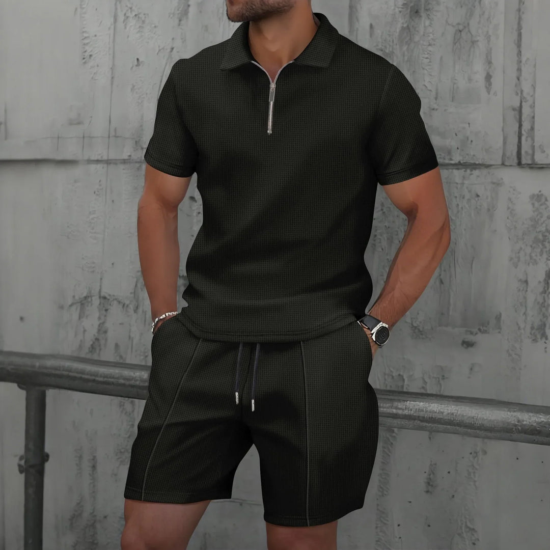 Herren Modell trägt das cremefarbene Polo Set entspannt im Freien.
