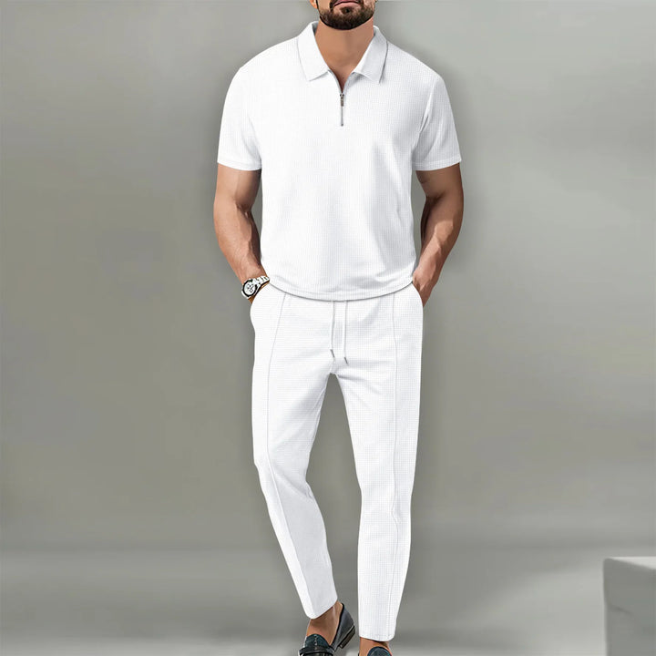 Herren Outfit in reinem Weiß, Poloshirt mit Kragen und kurze Hose.