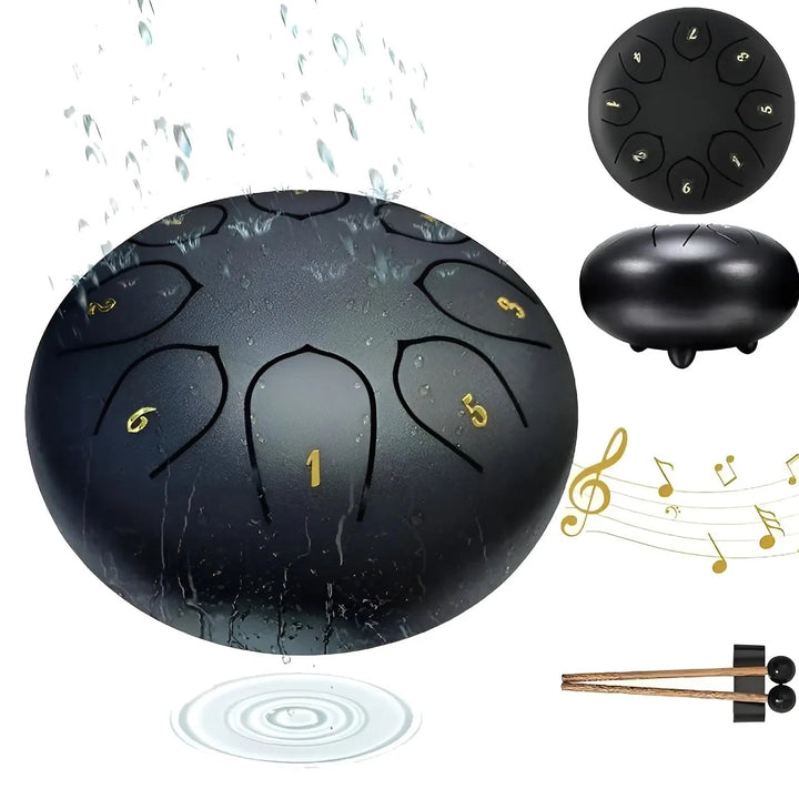 Schwarze Stahlzungentrommel mit Wasser, Noten und Schlägeln, ideal für Outdoor-Musik.