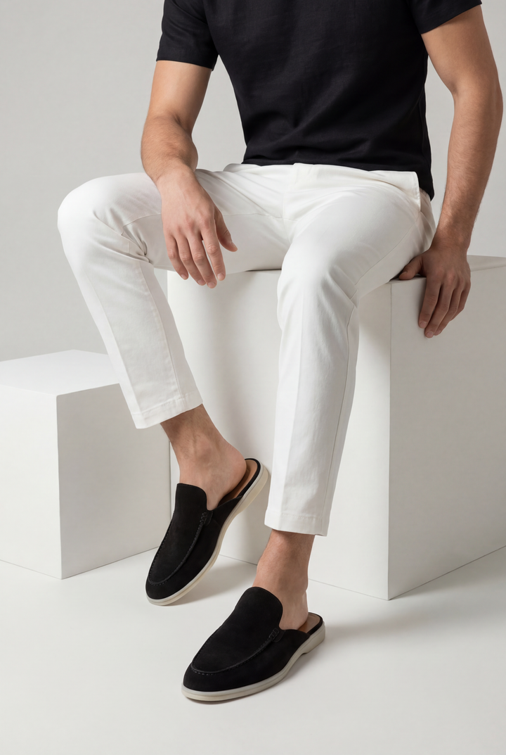 Mann trägt schwarze Herren Mules mit weißer Hose