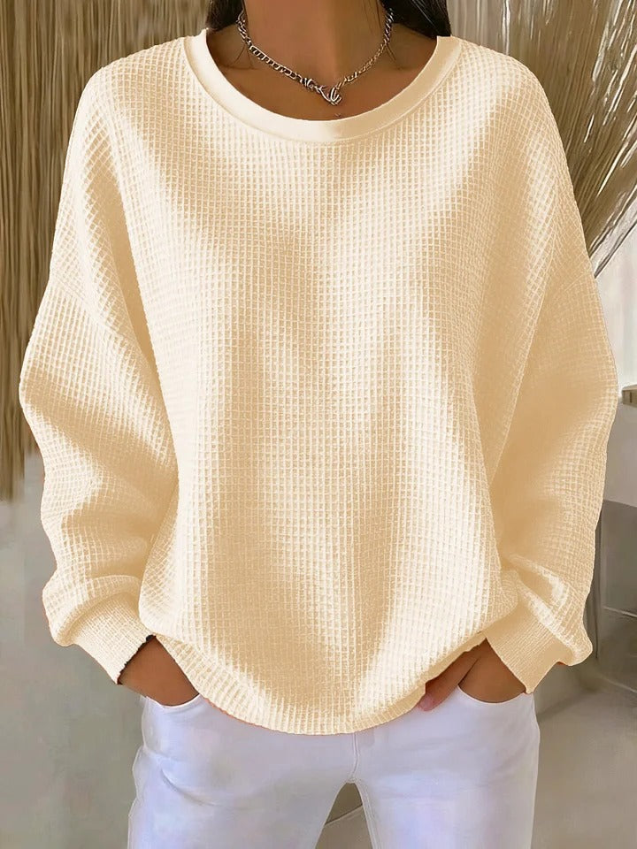 Nahaufnahme des weichen Waffelstrickmusters an einem Damen Pullover, warm & stilvoll.