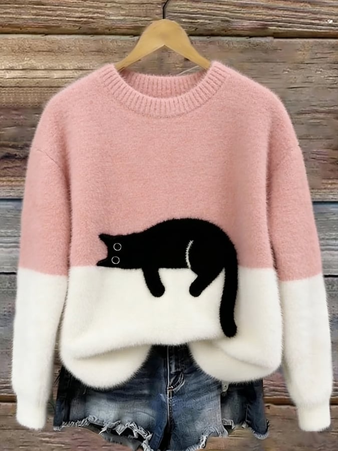Rosa Oversized Pullover mit Katzenmotiv auf einem Kleiderbügel