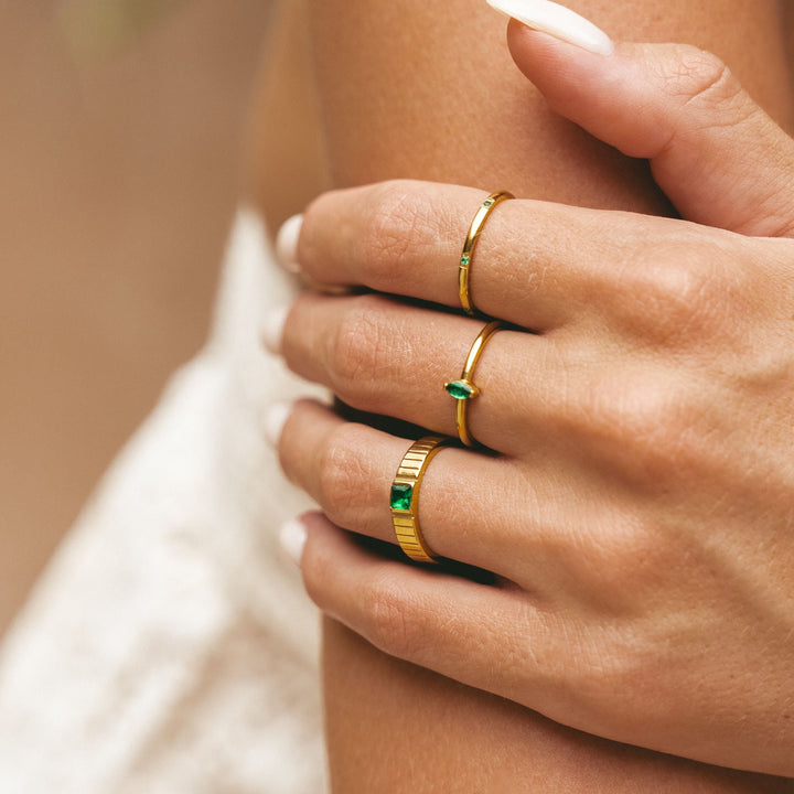 Nahaufnahme der Hand mit goldenem Statement-Ring und passendem Armschmuck