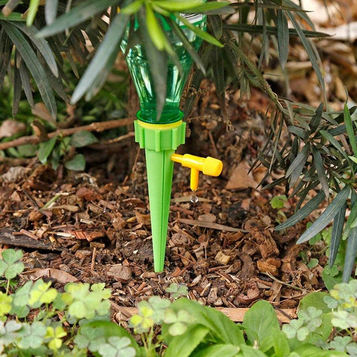 Automatische Pflanzenbewässerung, grünes Kunststoffsystem mit Flaschenanschluss, Urlaubssicherheit für Gartenpflanzen.